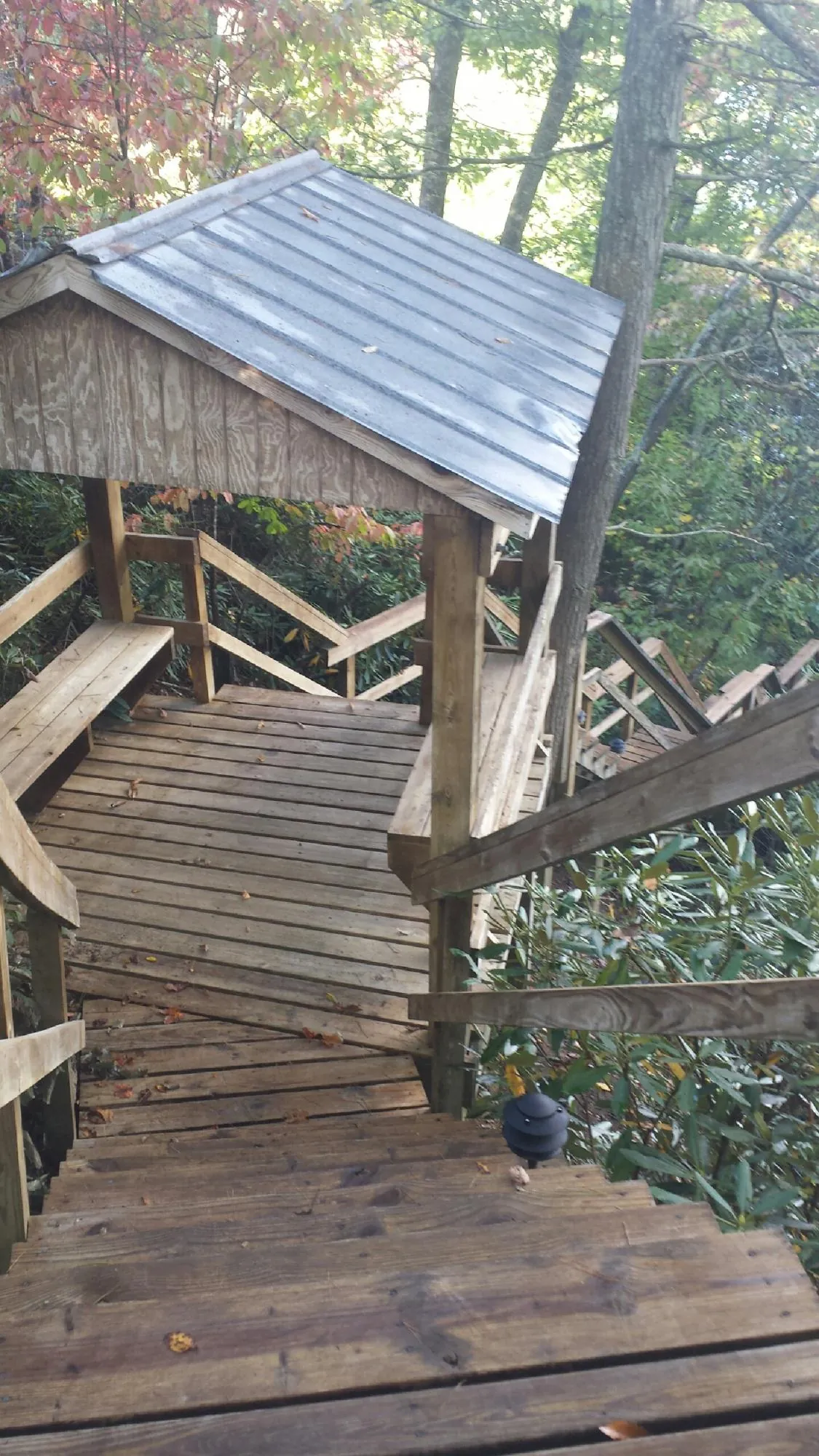 Metal roofed shelter over wooden steps on a wooded walkway — Skylight Repair & Installation work by our crew in Wakefield